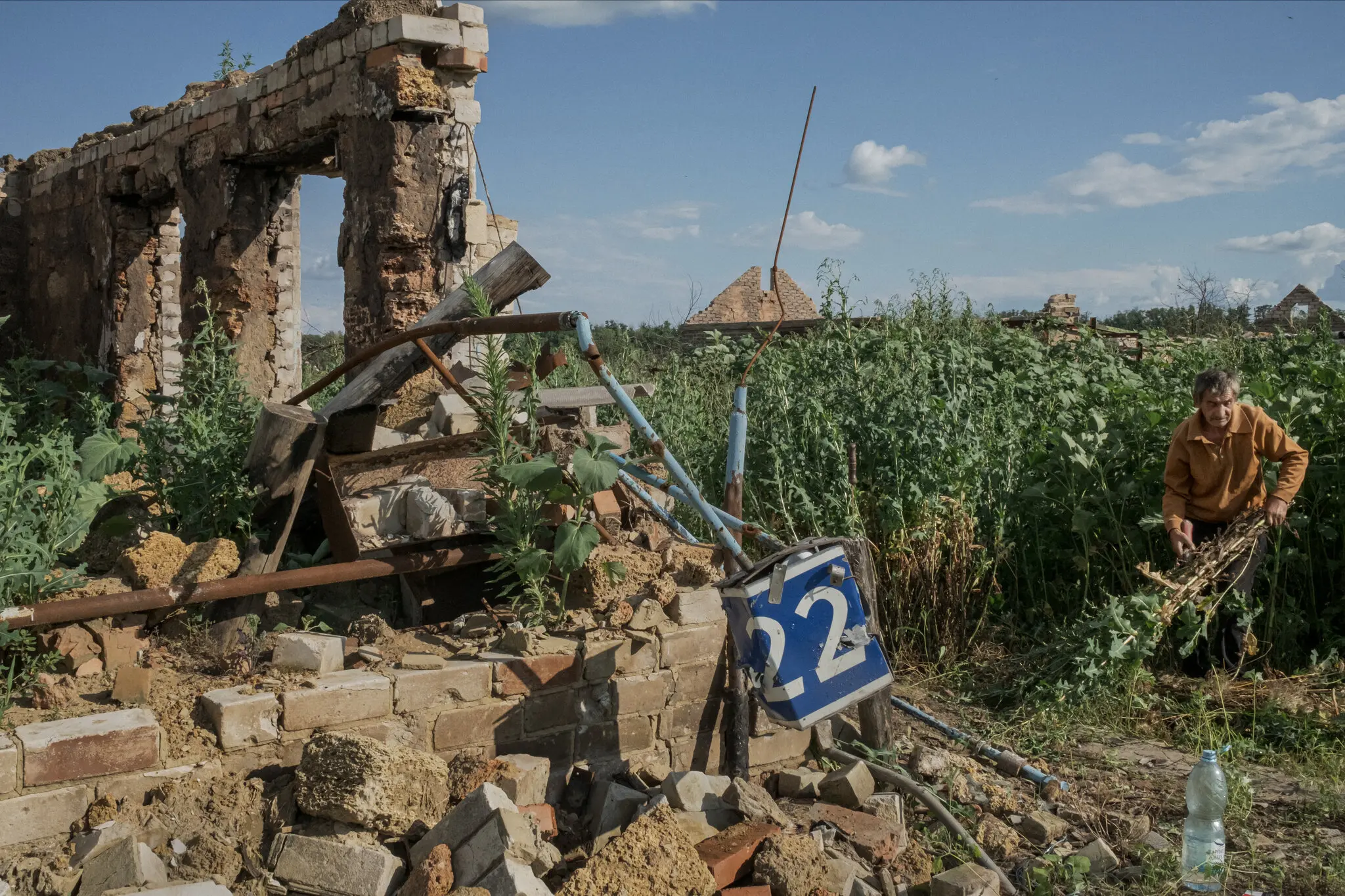 61-річний Віктор Каліберда цього місяця прибирає рослинність біля зруйнованого будинку біля свого будинку в Сулигівці